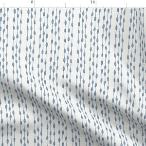 May include: A white fabric with a repeating pattern of blue, hand-drawn, oval shapes. The ovals are arranged in vertical lines, creating a subtle, textured look.