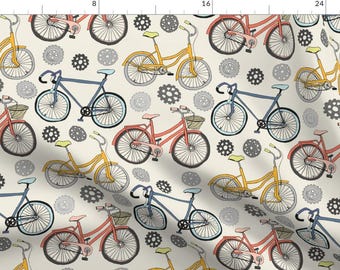 May include: A repeating pattern of bicycles in various colors, including yellow, red, and blue, with black outlines. The bicycles are interspersed with gray gear illustrations on a cream background.