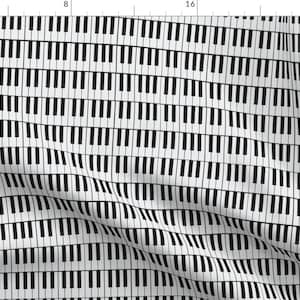 May include: A black and white repeating pattern of piano keys. The keys are arranged in a staggered pattern, creating a visual illusion of movement. The pattern is repeated across the entire surface of the fabric.