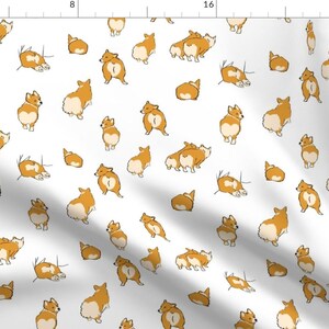 May include: A white fabric featuring a repeating pattern of illustrated orange and white Corgi dogs in various poses, including sitting, standing, and lying down, with a visible ruler along the top and left edges measuring up to 24 inches.
