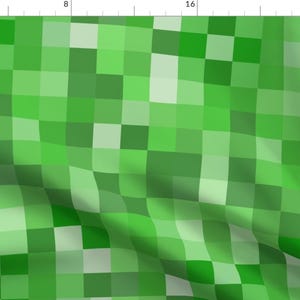 Könnte beinhalten: Ein grünes und weißes Pixelmuster mit einem leichten Welleneffekt. Das Muster besteht aus Quadraten in verschiedenen Grüntönen und Weiß.