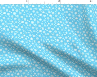 May include: A light blue fabric with a white snowflake pattern. The fabric is folded in the bottom right corner.