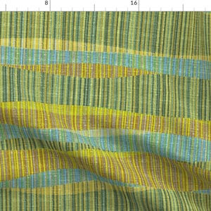 May include: A woven fabric with a striped pattern in shades of green, yellow, and blue. The fabric has a textured surface and a slightly irregular weave.