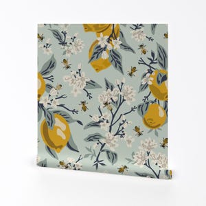 以下が含まれることがあります： 薄い青色の背景に、黄色のレモン、白い花、ミツバチが描かれたシームレスなパターン。壁紙、布、包装紙に最適です。