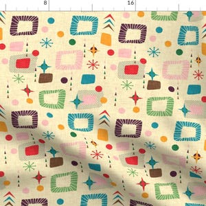May include: A fabric featuring a repeating pattern of rounded squares in teal, purple, pink, and green on a cream background. The design includes small starbursts, solid circles, and triangles in red, yellow, and brown, creating a dense, colorful graphic print.