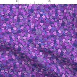 May include: A purple fabric with a repeating pattern of various purple and blue dice. The dice are outlined in black and have different numbers on their faces.