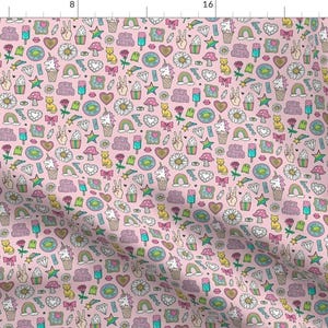 Könnte beinhalten: Ein rosa Stoff mit einem sich wiederholenden Muster aus verschiedenen bunten Kritzeleien, darunter Herzen, Sterne, Regenbögen, Einhörner und die Worte "Good Vibes Only".