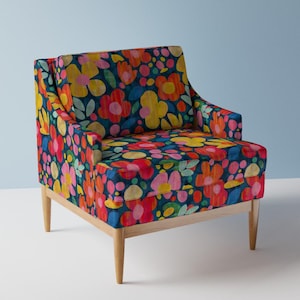 May include: A colourful armchair with a floral pattern in shades of red, pink, yellow, and blue on a dark blue background. The chair has wooden legs.