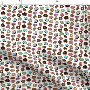 May include: A white background with a repeating pattern of colourful doughnuts. The doughnuts are in various colours, including pink, blue, green, brown, and white. Each doughnut has a different topping, such as sprinkles, chocolate, or icing.