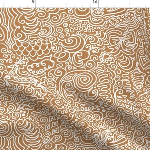 May include: A brown fabric with a white pattern of swirls, lines, and shapes. The pattern is reminiscent of gingerbread cookie icing.