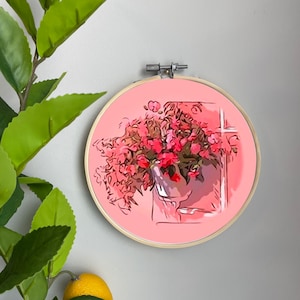 May include: A pink embroidery hoop with a hand-drawn illustration of a bouquet of pink flowers in a white vase. The flowers are in a window with a pink background.