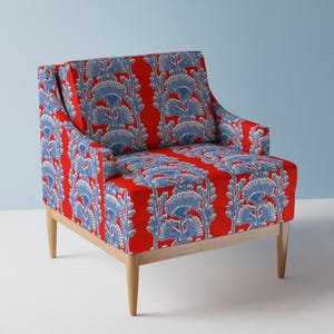 Könnte beinhalten: Roter Sessel mit blau-weißem Blumenmuster. Der Stuhl hat ein Holzgestell und Beine. Die Polsterung zeigt ein sich wiederholendes Design aus stilisierten Blumen und Blättern.