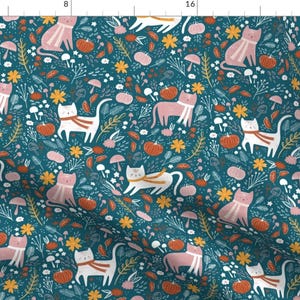 May include: A teal blue fabric with a repeating pattern of pink and white cats wearing scarves, orange pumpkins, and yellow flowers.