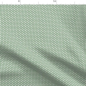 May include: A green and white fabric with a repeating pattern of small squares. The fabric has a subtle texture and a slightly wrinkled appearance.