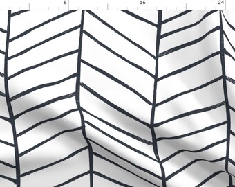 May include: A white fabric with a black and white chevron pattern. The pattern is made up of thick, hand-drawn lines.