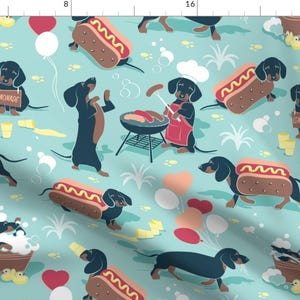 Op de afbeelding: Een herhalend patroon met cartoon teckels die genieten van een zomerse picknick. De honden worden afgebeeld met hotdogs, limonadestands en grillen. De achtergrond is lichtblauw met verspreide harten, ballonnen en gras.