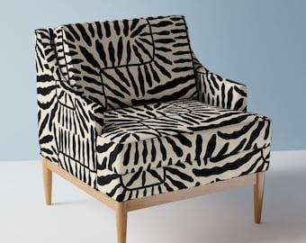 May include: A black and white patterned armchair with wooden legs. The chair has a geometric design with a black and white pattern.