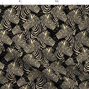 May include: A black and cream fabric with a repeating pattern of zebra heads. The zebra stripes are black and cream.