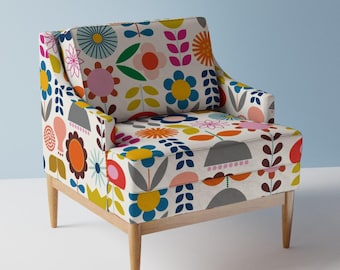 May include: A colorful armchair with a floral pattern featuring red, orange, yellow, green, blue, and pink flowers on a white background. The chair has wooden legs.