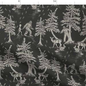 Peut inclure: Un tissu à motif noir et blanc avec un motif répétitif d'arbres, de cerfs, de Bigfoot et d'extraterrestres. Le motif rappelle un motif toile traditionnel.