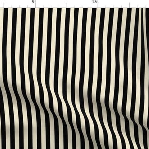 Op de afbeelding: Crème- en zwart gestreepte stof. De stof heeft verticale strepen in afwisselende kleuren. De strepen zijn ongeveer 2,5 cm breed. De stof heeft een licht golvend patroon, wat textuur aan het ontwerp toevoegt. Geschikt voor naaiprojecten.