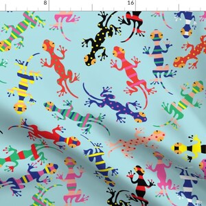 May include: A repeating pattern of colorful lizards on a light blue background. The lizards are in various poses and have different patterns, including stripes, polka dots, and solid colors.