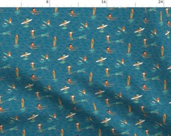May include: A teal blue fabric with a repeating pattern of people paddleboarding on a turquoise blue ocean. The people are wearing orange and white clothing and the paddleboards are orange.