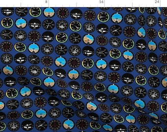 May include: A blue fabric with a repeating pattern of black and white airplane instrument gauges. The gauges are circular and have various markings and numbers.