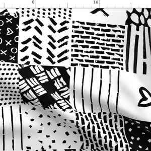 Peut inclure: Tissu noir et blanc avec un motif patchwork composé de différents motifs géométriques, notamment des rayures, des pois et des zigzags.