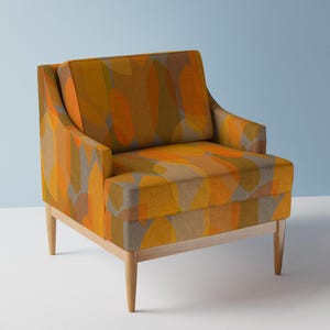 Può includere: Una poltrona moderna in stile mid-century con un motivo geometrico in tonalità arancio, giallo e marrone. La poltrona ha una struttura e gambe in legno.
