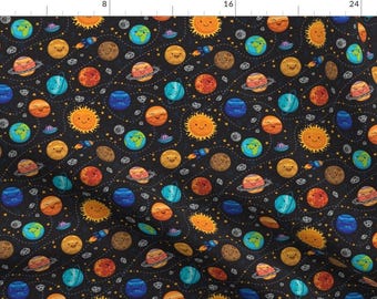 May include: A black fabric with a repeating pattern of planets, stars, and rockets. The planets are all smiling and have different colors. The stars are yellow and the rockets are red.