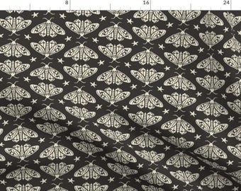 May include: A dark charcoal gray fabric featuring a repeating pattern of off-white moths with intricate wing details and small five-pointed stars scattered between them. The design is printed on a flat textile surface with a visible ruler at the top.