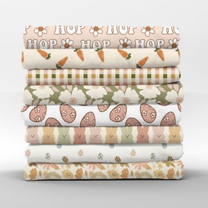May include: A stack of eight fabric panels featuring various Easter-themed designs. The patterns include bunnies, eggs, flowers, and the repeated word "HOP".