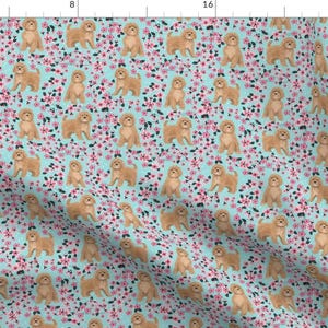 Könnte beinhalten: Ein nahtloses Muster mit einem hellblauen Hintergrund und einem sich wiederholenden Design aus Goldendoodle-Hunden und rosa Blumen.