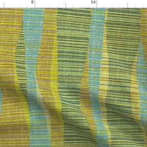 May include: A fabric with a striped pattern in shades of green, yellow, and blue. The fabric is woven with a subtle texture and has a slight sheen.