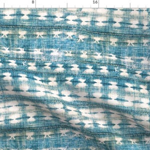 May include: Blue and white tie-dye patterned fabric. The design features horizontal stripes with repeating white shapes against a textured blue background. The fabric has a slightly distressed appearance, with a vintage feel.
