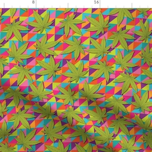 Peut inclure: Un motif géométrique coloré avec des feuilles de marijuana vertes. L'arrière-plan est un mélange de rose, orange, jaune, bleu et violet.