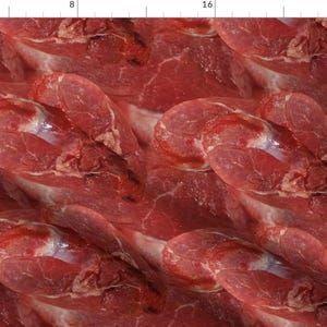 May include: A close-up of raw red meat, showing the marbling and texture of the beef. The meat is arranged in a pattern, creating a visually appealing and appetizing image.