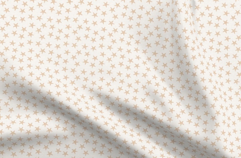Pu&ograve; includere: Tessuto bianco con un motivo ripetitivo di piccole stelle beige.