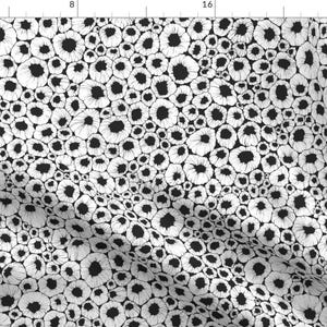 Puede incluir: Patrón sin costuras en blanco y negro con un diseño repetitivo de círculos blancos con centros negros. Los círculos están dispuestos en un patrón aleatorio y se superponen.
