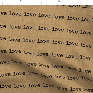 May include: A brown fabric with the word "love" repeated in black text.