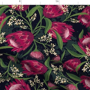 Op de afbeelding: Een donkerblauwe stof met een herhalend patroon van roze protea-bloemen en witte bloesems. De protea-bloemen zijn groot en hebben een textuur.