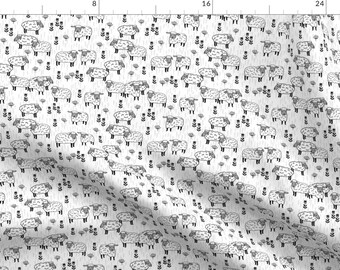 May include: White fabric with a black and white repeating pattern of sheep. The sheep are drawn in a simple, stylized manner.