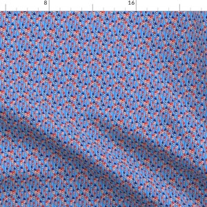 May include: A blue fabric with a repeating pattern of red, white, and blue flags. The flags are arranged in a diagonal pattern.