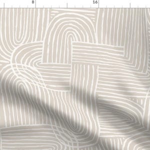 May include: A fabric with a repeating pattern of white, curved, and straight lines on a beige background. The design features overlapping shapes, creating a textured, abstract look. The lines vary in thickness, adding visual interest to the textile.