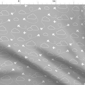 May include: A seamless pattern featuring white airplanes flying in a gray sky with white clouds. The airplanes are flying in a straight line with a dotted line behind them.