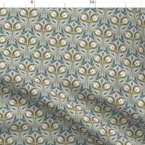 May include: A fabric featuring a repeating pattern of white tulip-like flowers with brown centers and green stems, interspersed with dark blue leafy sprigs on a light sage green background. The design is displayed on a textile with a visible weave.