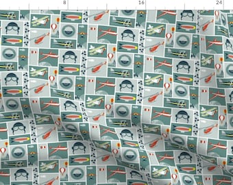 May include: A repeating pattern of various airplanes, hot air balloons, and airships in shades of red, blue, yellow, and green on a light blue background.