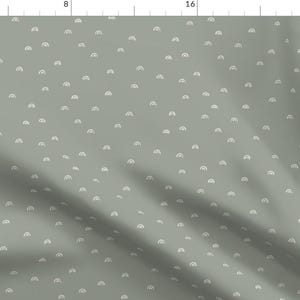 May include: A sage green fabric with a repeating pattern of white, hand-drawn rainbows. The fabric is textured and has a subtle sheen.