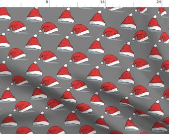 May include: A repeating pattern of red Santa hats on a gray background. The hats are all facing the same direction and are slightly tilted.